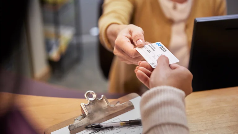 Customer hands an health insurance card to a provuder